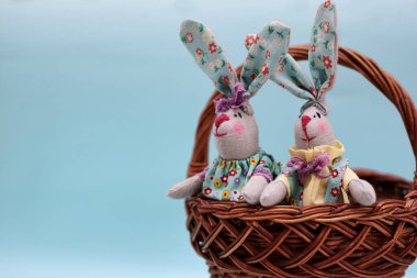 Bir çift renkli el yapımı paskalya tavşanı açık mavi naneli arka planda izole edilmiş. Paskalya tatili süslemeleri.