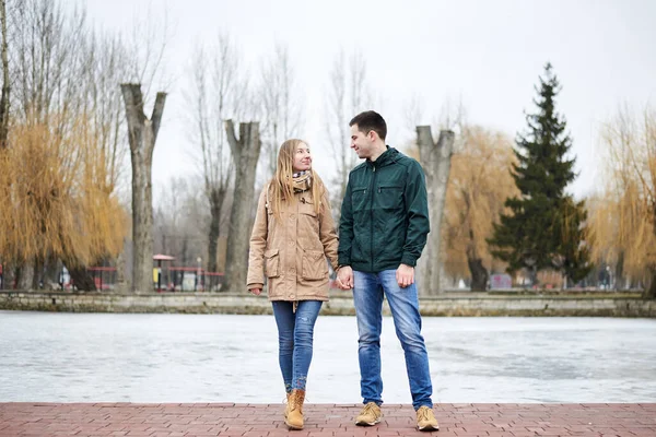 Casal Jovem Apaixonado Vestindo Jaquetas Casuais Bege Verde Frente Lago — Fotografia de Stock