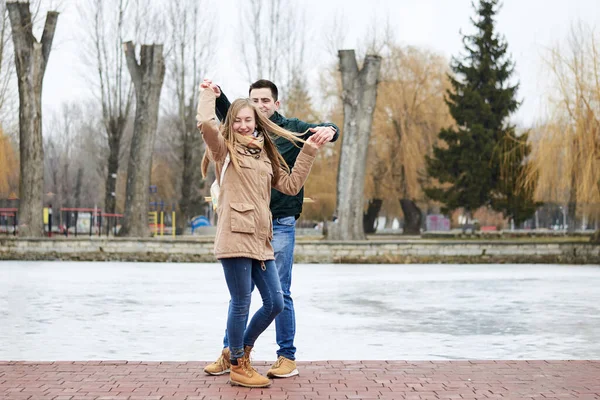 Casal Jovem Apaixonado Vestindo Jaquetas Casuais Bege Verde Frente Lago — Fotografia de Stock