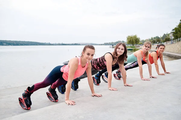Grupo Jovens Encaixam Mulheres Magras Saltos Kangoo Treinando Frente Lago — Fotografia de Stock
