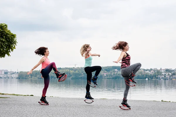 Grupo Jovens Encaixam Mulheres Magras Saltos Kangoo Treinando Frente Lago — Fotografia de Stock