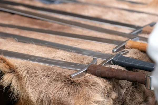 Medieval weapons replicas for close combat used in wars on display on animal fur