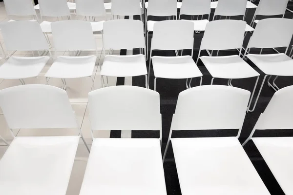 Filas de sillas de plástico blanco para reuniones formales, conferencias, conferencias, ceremonias de graduación. Habitación llena de sillas blancas vacías . —  Fotos de Stock