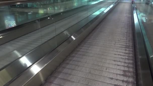 空港の可動式コンベアベルトを通過する人々 国際空港ターミナルのエスカレーターや旅行者を通り過ぎる人たち — ストック動画