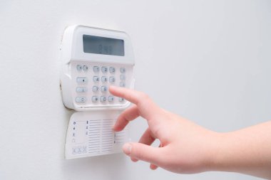Bir dairenin alarm sistemi şifresi ne girerken kadın el, iş yeri ofisi. Kauçuk ve hırsıza karşı gözetim ve koruma konsolu