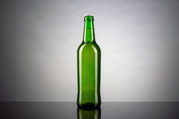 Kalte ungeöffnete Flasche Bier mit Deckel auf weißem Hintergrund. Glas gekühltes Weizen- oder Lagerbier auf hellem Hintergrund — Stockfoto