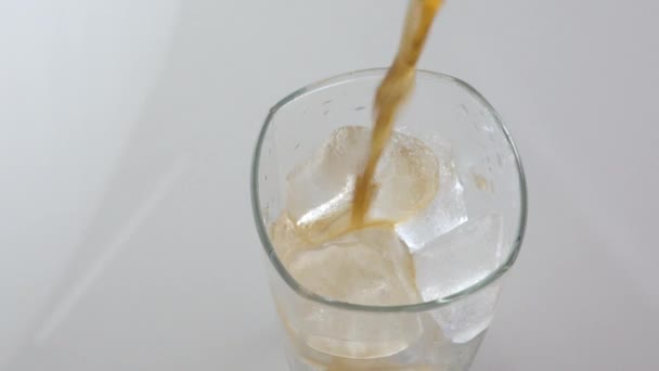 冷たいさわやかなコーラは テキストのためのスペースと白い背景に氷とガラスに注ぐ カフェイン入りの冷たい飲み物のアイスドリンク — ストック動画