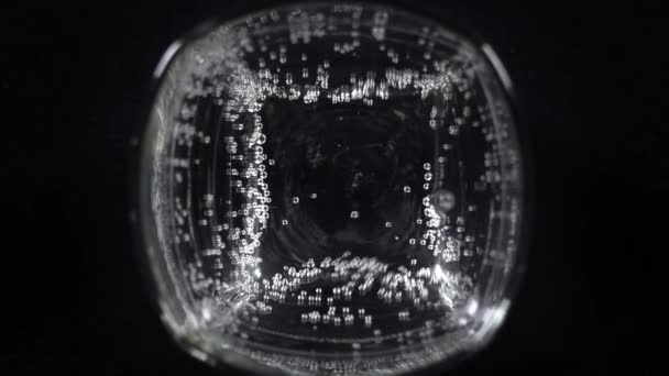 ガラスの中のミネラルウォーターの泡を閉じます 暗い背景に酸素ボールと炭酸新鮮な輝く飲み物のマクロショップ — ストック動画