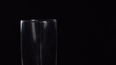 Taze mineralleri masaya cam parçaları dökerek. Siyah zemin üzerinde oksijen topları olan taze köpüklü içecek.