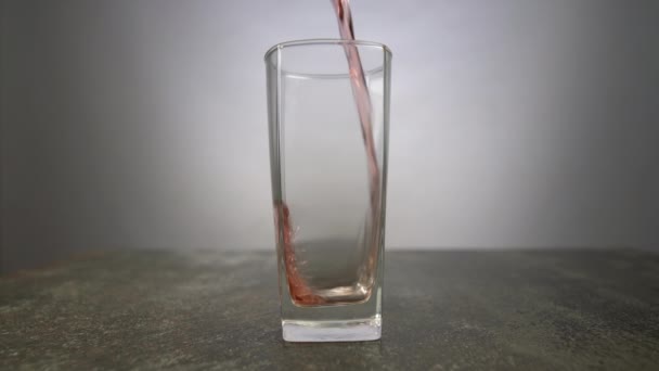 光を背景にグラスに注ぐブドウジュース テーブルの上に赤い色のドリンクの新鮮なカクテルグラス — ストック動画