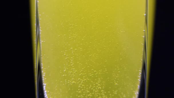 暗い背景に新鮮なミネラルウォーターのガラスに溶解ビタミンCタブレットの閉じる 黄色の泡状液体のマクロショット酸素ボール — ストック動画