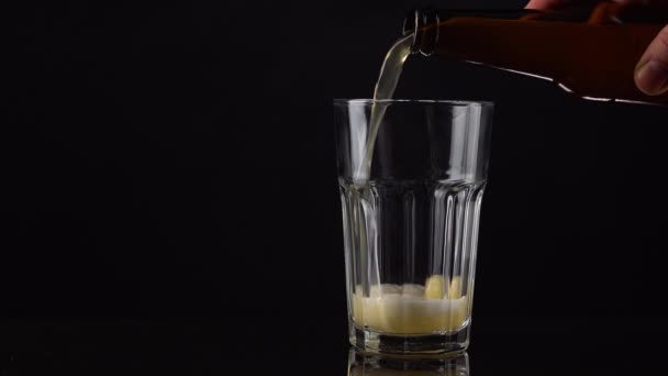 将新鲜而冷的工艺啤酒倒入黑色背景的白色泡沫玻璃杯中 深色背景的发泡小麦或啤酒 — 图库视频影像
