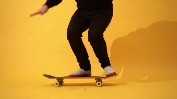 滑板手表演滑板戏法 弹出它在混凝土上 运动员在黄色背景上练习跳跃 为比赛做准备 — 图库视频影像