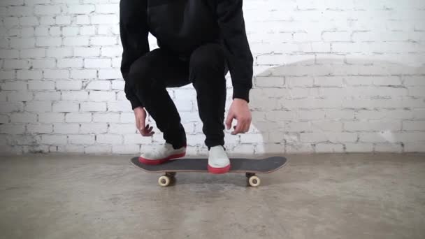 スケートボードのトリックを実行するスケートボーダー コンクリート上のヒールフリップ 白い背景でジャンプ練習し 競技の準備をするアスリート — ストック動画