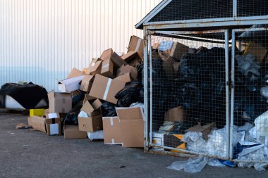 Çöp kutusunun yanındaki karton kutular. Şehirde kağıt atığı yığını var. Kağıt geri dönüşümü, kimse