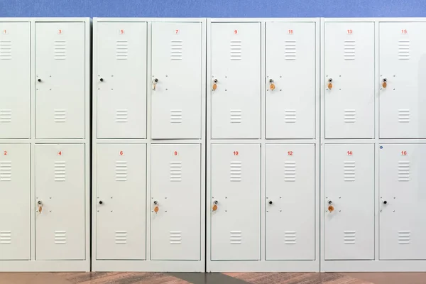 Een rij van grijze metalen schoolkluisjes met sleutels in de deuren. Opslagruimte in de gang van de onderwijsinstelling — Stockfoto