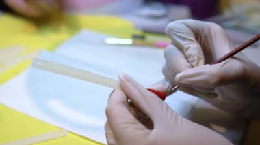 Tırnak üstüne fırçayla kadın boyası yakın plan. Jel tırnak boyası, tırnak sanatı.