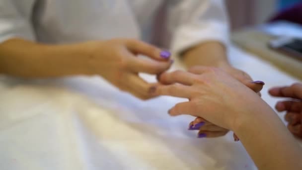 Detailní záběr fyzioterapeuta provádějícího ruční masáž. Masérka tiskne ženské dlaně na kosmetické klinice