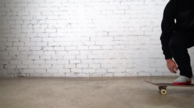 Kaykaycı, kaykay numarası yapıyor. Pop, beton üzerinde kayıyor. Beyaz arka planda atlama antrenmanı yapan sporcu, yarışmaya hazırlanıyor 