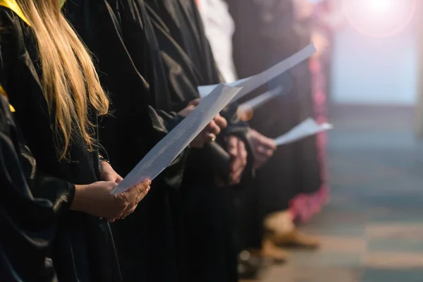 Müzikal puanı tutan ve öğrenci mezuniyet gününde Üniversitesi, üniversite diploması başlamasından şarkı Koro şarkıcıları