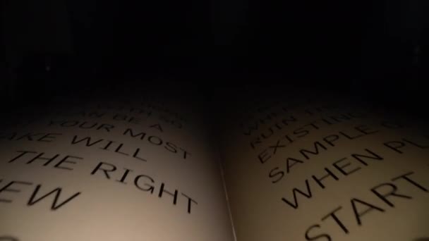 Dolly prise de vue de la caméra glissant dans le livre entre les lettres. Lettres et mots latins sur un livre ouvert avec un fond dramatique noir. Éducation, concept de connaissance