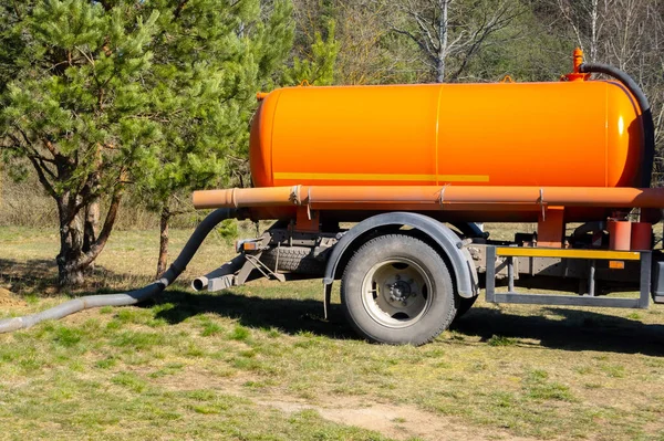 Sewer tank truck providing cleaning service outdoor. Specialized car, sewage pumping machine