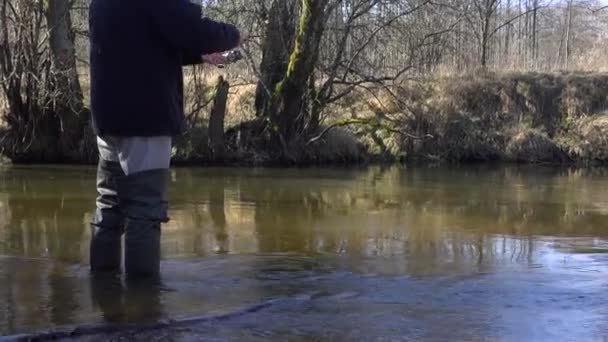 Ψαράς Λαστιχένιες Μπότες Ψαρεύει Πέστροφες Ένα Ρυάκι Μια Ηλιόλουστη Μέρα — Αρχείο Βίντεο
