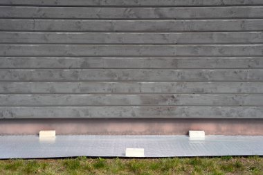 Tablolar için duvarın yanındaki yerde muşamba var. Duvar boyamasından önce hazırlık. Kimse.