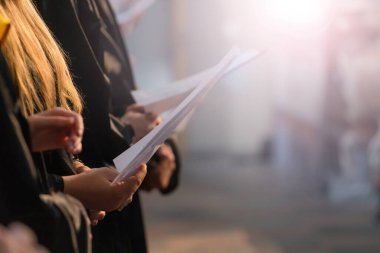 Müzikal puanı tutan ve öğrenci mezuniyet gününde Üniversitesi, üniversite diploması başlamasından şarkı Koro şarkıcıları