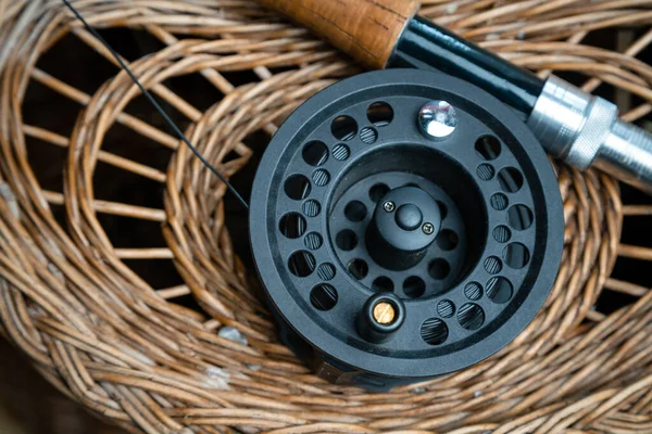 stock image Close up of fly fishing rod with reel next to braided basket. Fly fishing equipment still life. Nobody