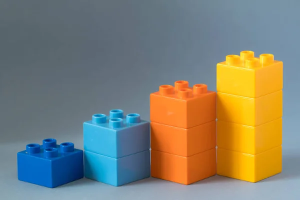 Growing bar chart from color toy blocks on blue background. — Stock Photo, Image