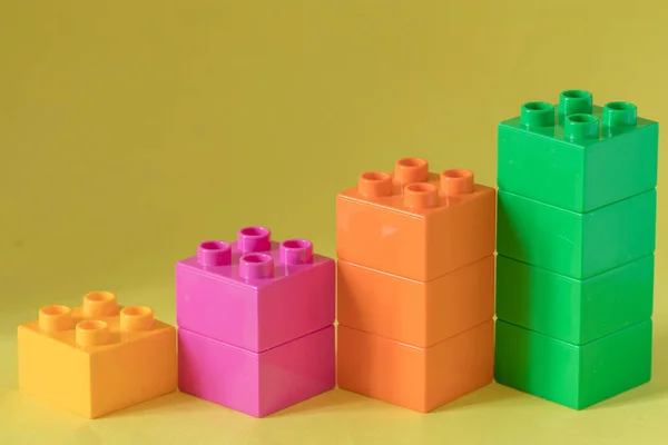 Gráfico de barras crescente de blocos de brinquedos de cor no fundo amarelo . — Fotografia de Stock