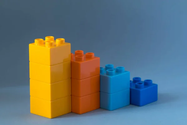 Gráfico de barras crescente de blocos de brinquedos de cor no fundo azul . — Fotografia de Stock