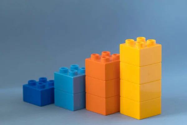 Gráfico de barras crescente de blocos de brinquedos de cor no fundo azul . — Fotografia de Stock