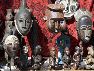 Afrika maskeleri ve heykeller bir pire pazar kırmızı bir arka plan üzerinde bir seçim