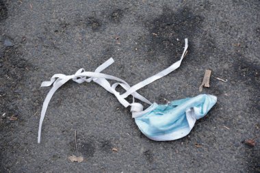 Sokağa atılmış bir cerrahi maske.