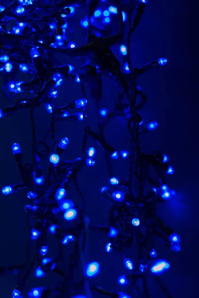 Guirnalda de Navidad con luces azules sobre un fondo oscuro . —  Fotos de Stock