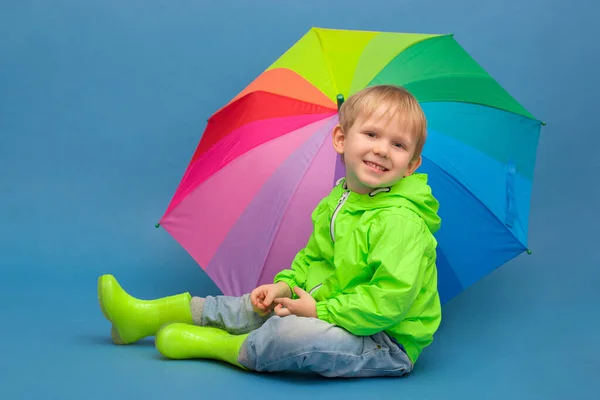 Caucasian Child Sits Windbreaker Jacket Rubber Boots Umbrella Rainbow Blue — Stock Photo, Image
