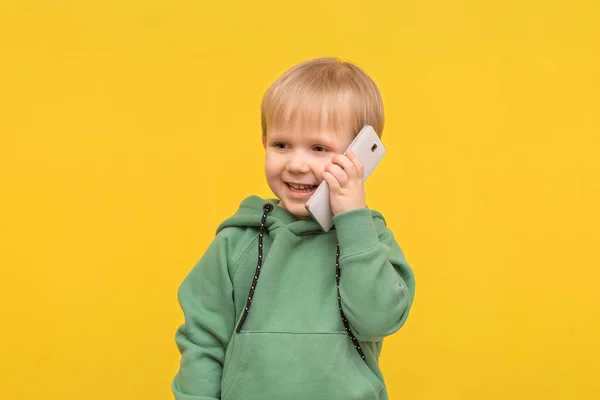 Blonďatý Chlapec Mluví Telefonu Smartphonu Žlutém Jarním Pozadí Koncepce Článků — Stock fotografie