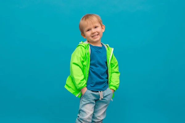 Šťastný Blonďatý Chlapec Světle Zeleném Větrovce Pláštěnku Který Směje Pozadí — Stock fotografie