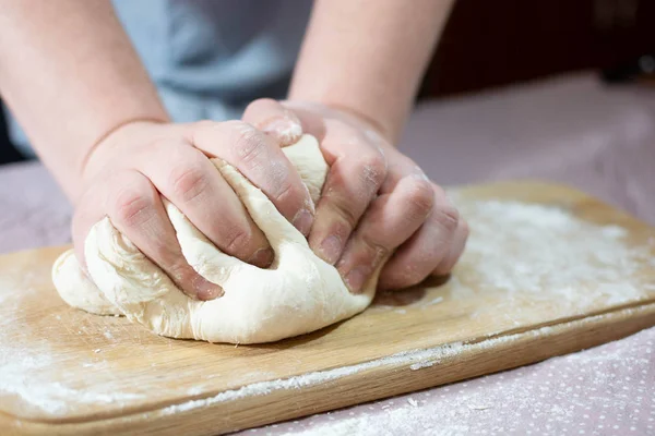 Knead the dough on a wooden board — Stock Photo, Image