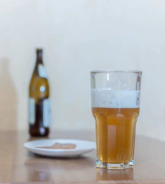 Bière dans un verre sur une table en bois en arrière-plan une bouteille — Photo