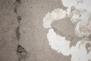 Çökmüş kireç ve çatlaklarla kaplı bir kil duvarın arka planı.
