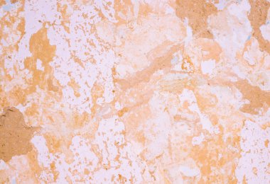 Dökülen kireç ve eski boyalarla kaplı bir kil duvarın arka planı.