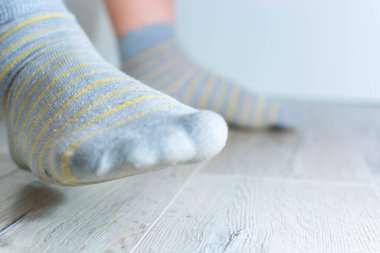 Sarı çizgili erkek gri çorapları. Bacakları çorapta, bacakları havada. Düşük başlangıç.