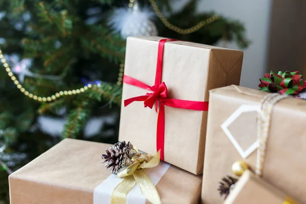 Ajándék dobozok karácsonyfa a háttérben — Stock Fotó