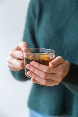 Ellerinde cam çay fincanı