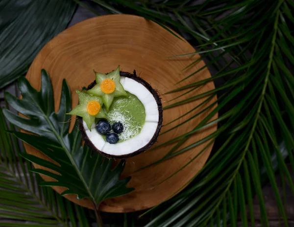 Coco con batido sobre tabla de madera con hojas — Foto de Stock