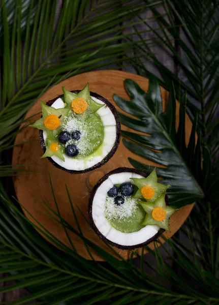 Batido en cocos con bayas y hojas sobre fondo — Foto de Stock