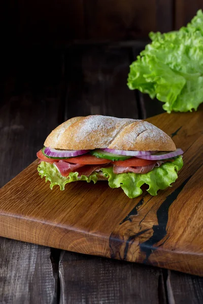 Длинный сэндвич с итальянским мясом на деревянной доске — стоковое фото